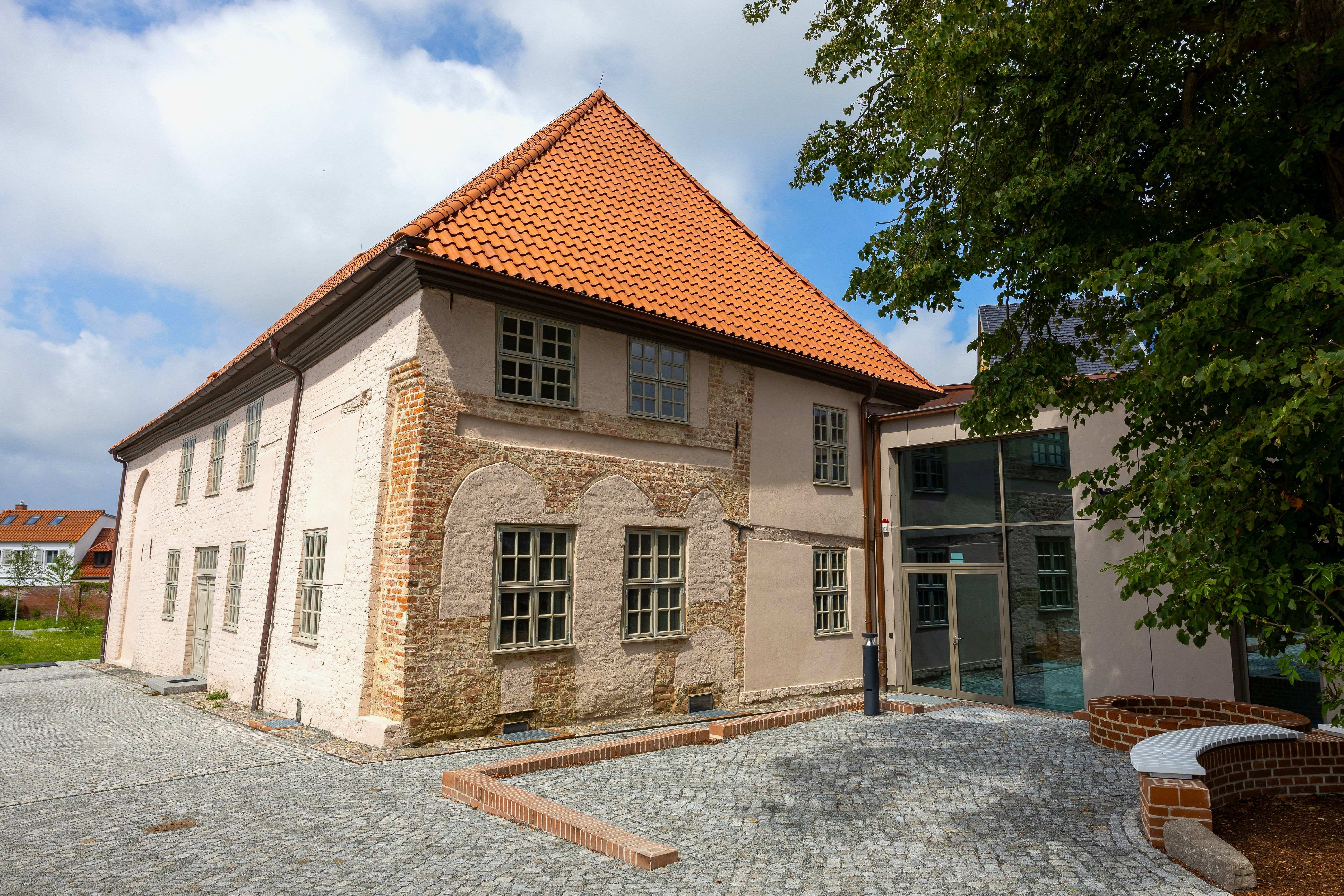 Haus von der Vorderseite mit Eingang rechts, hinten links der Garten